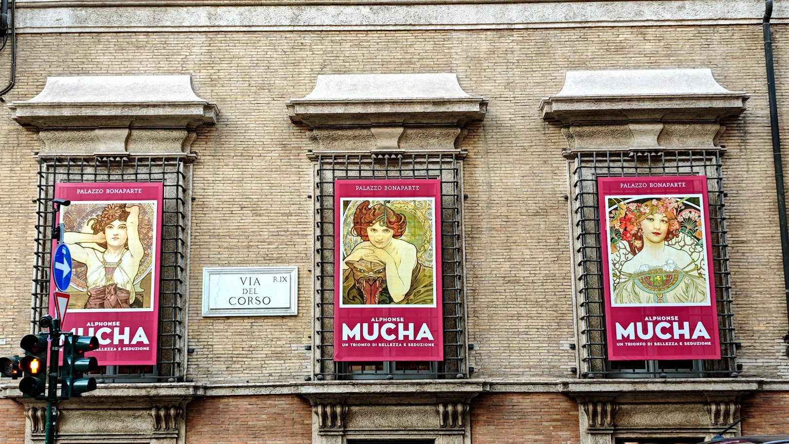 פרסומות לתערוכה של אלפונס מוחה על חלונות פלאצו בונפרטה. צילום: צבי חזנוב